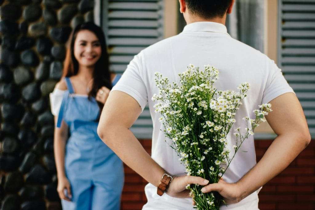 man-holding-baby-s-breath-flower-in-front-of-woman-standing-near-marble-wall-stockpack-pexels | WEDISTRY BLOG emotional compatibility